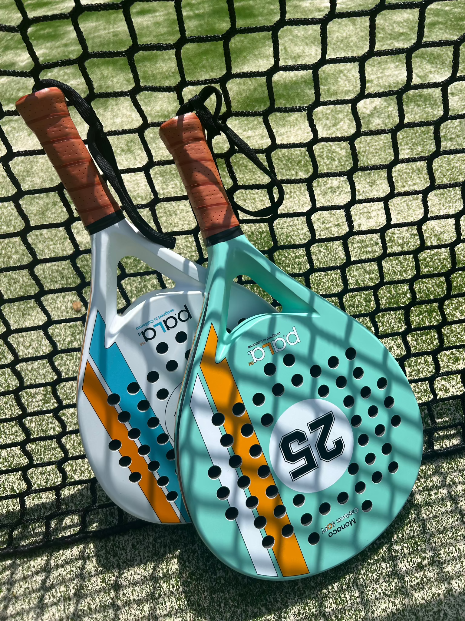 Aqua and white P.ALA padel rackets with the numbers 25 and 28, designed for optimal performance and control