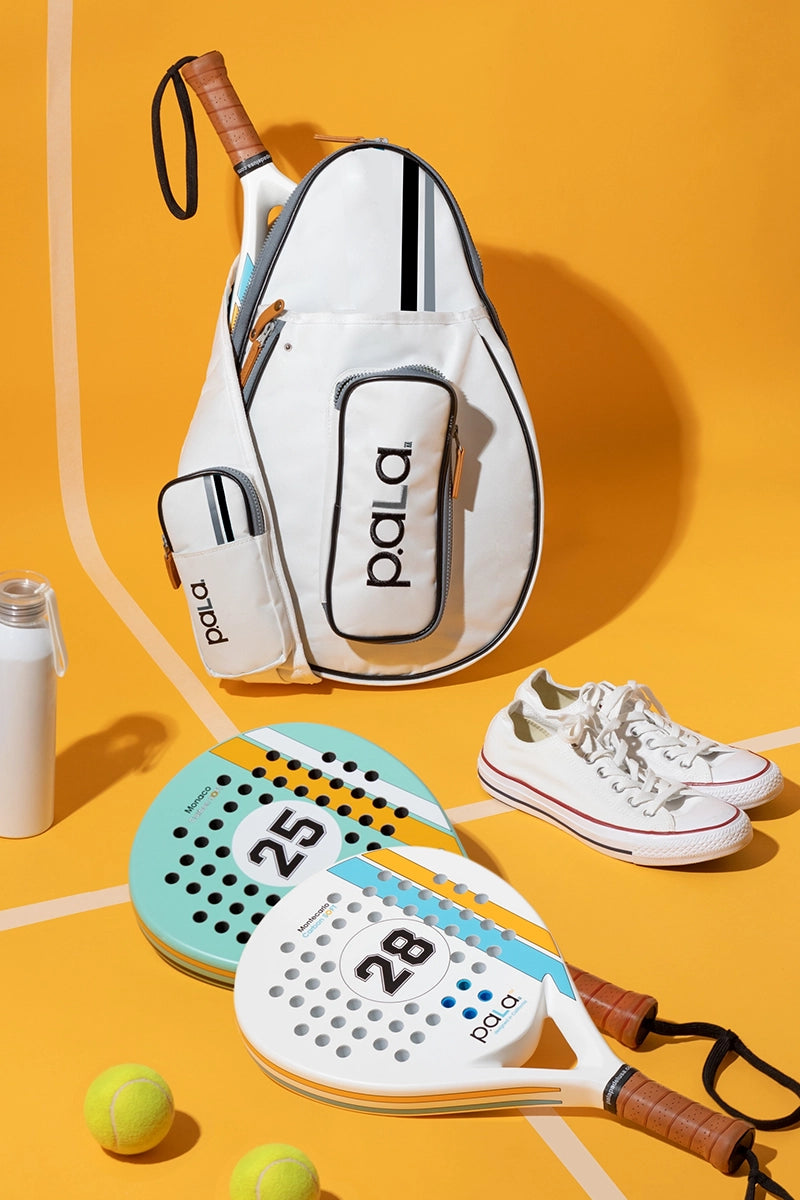 Paddle tennis rackets, balls, and shoes on a yellow background with 'p.ala' branding.