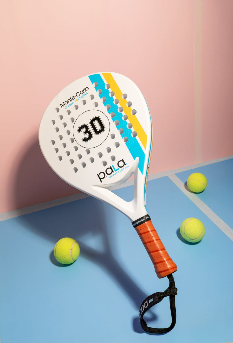 Paddle racket with 'pala' branding on a blue and pink background
