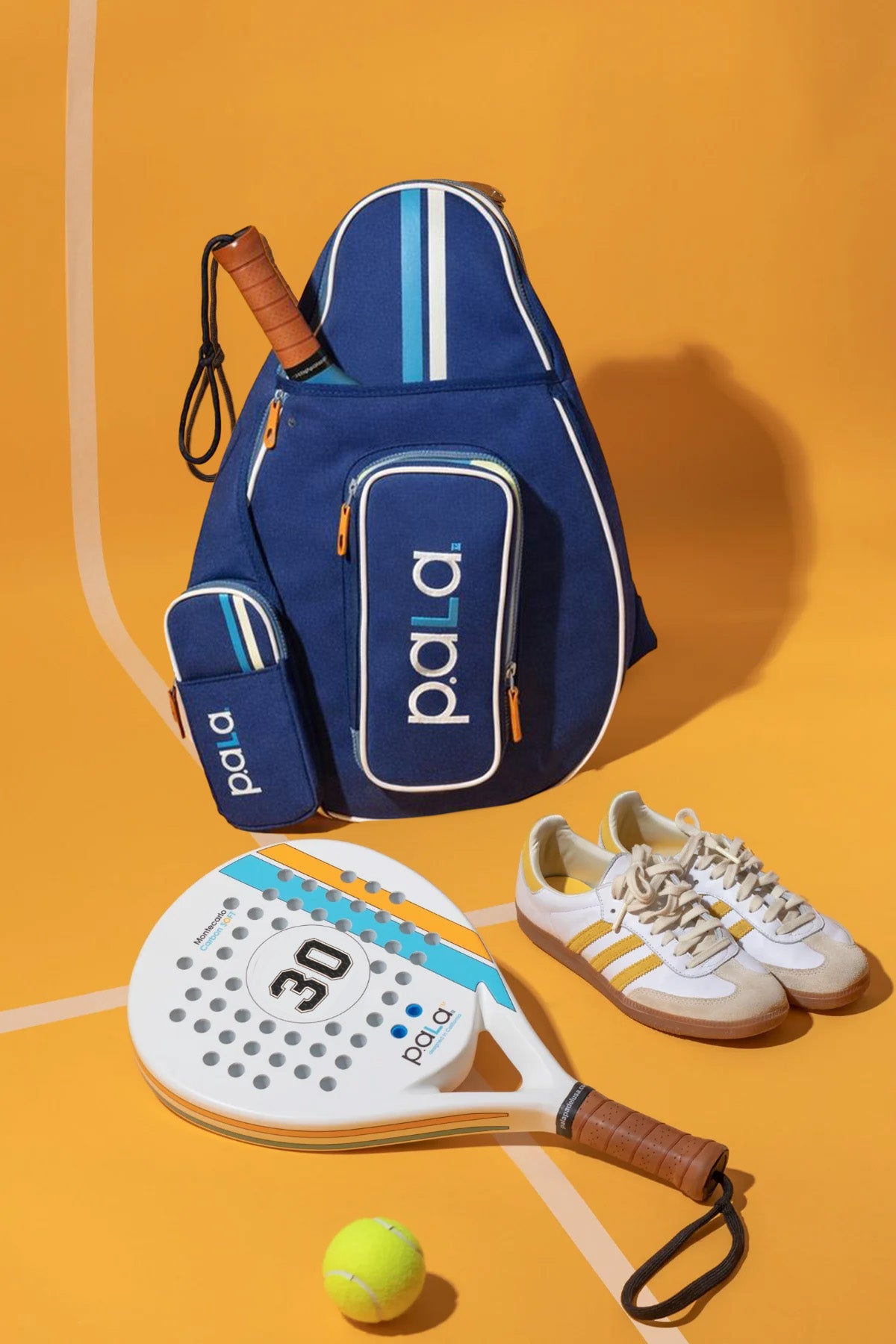 blue sling padel bag with white padel racket on a padel court