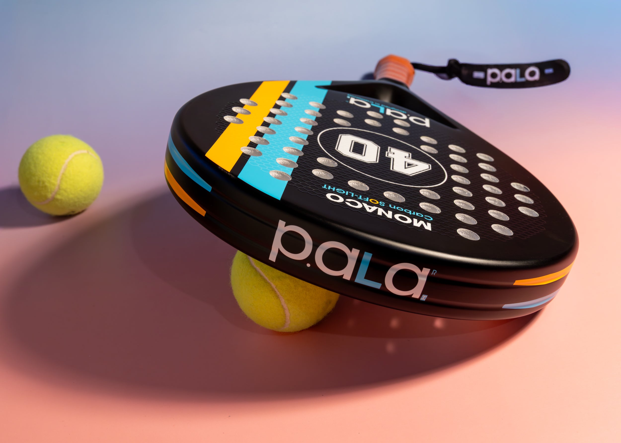Pala padel racket with two tennis balls on a gradient background