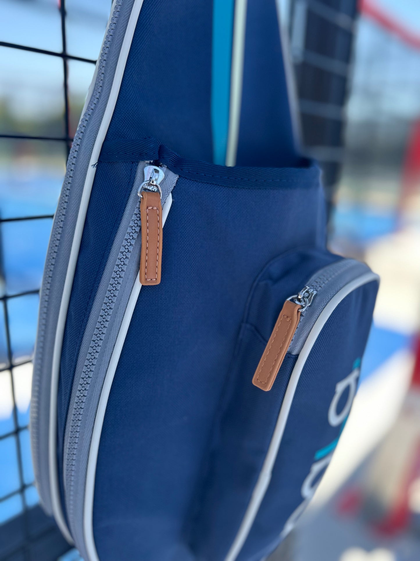 blue padel bag hanging from court